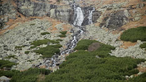 Water-falls-in-slow-motion-spreading-across-rocks-draining-into-green-shrub-and-shale-in-Sliezsky-Dom,-High-Tatras-Slovakia