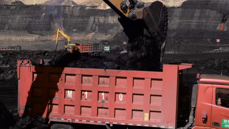 Excavator-Loading-Dump-Truck-With-Raw-Coal-From-The-Mine-In-Berau,-Indonesia