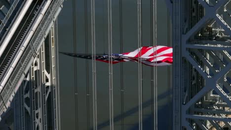Eine-Luftaufnahme-Des-Turms-Auf-Der-New-Jersey-Seite-Der-George-Washington-Brücke-Mit-Einer-Riesigen-Amerikanischen-Flagge,-Die-An-Einem-Sonnigen-Tag-Weht