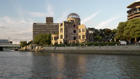 The-Genbaku-Dome-In-Hiroshima-Next-To-Motoyasu-River-During-Golden-Hour-With-People-Walking-Past