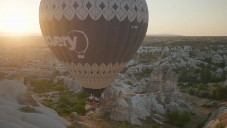 Heißluftballonpassagiere-Steigen-In-Die-Felsige-Tallandschaft-Bei-Sonnenaufgang-Hinab