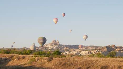 Heißluftballons-Schweben-über-Der-Sonnenverwöhnten-Landschaft-Des-Liebestals-Uchisar