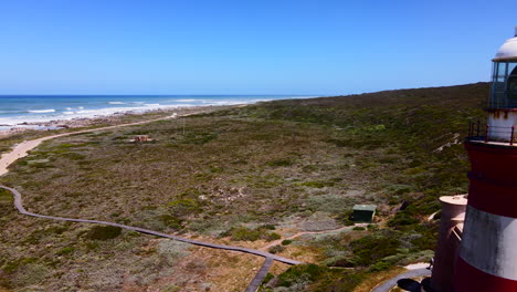 L'Agulhas-lighthouse-beacon-on-treacherous-rocky-coastline,-South-Africa