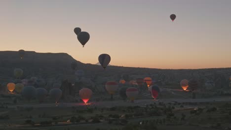 Los-Globos-Aerostáticos-Iluminan-La-Zona-De-Despegue-Del-Paisaje-Oscuro-De-La-Madrugada.