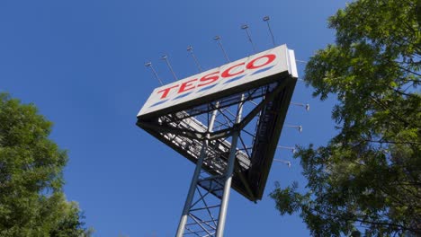 Pancarta-Tesco,-Logotipo-Del-Centro-Comercial-Británico-Con-El-Cielo-Azul