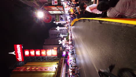 Eine-Vertikale-Aufnahme-Des-Geschäftigen-Nachtmarktes-In-Den-Straßen-Des-Berühmten-Yaowarat-Chinatown-In-Bangkok,-Thailand