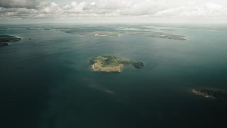 Luftaufnahmen,-Drohnenaufnahmen,-Kleine-Insel-Mit-Aufziehenden-Wolken,-See,-Finnland