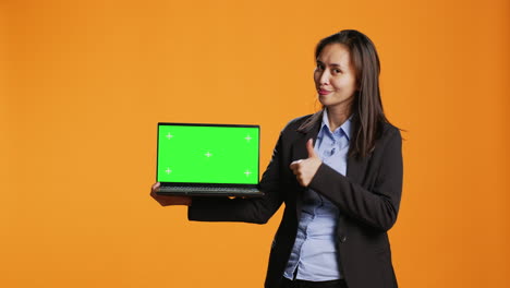 Business-person-holds-laptop-with-greenscreen-on-camera