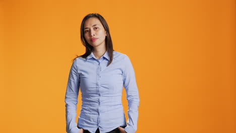 Young-smiling-woman-standing-over-orange-background