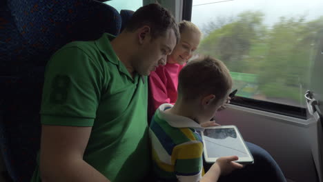 Familia-Viajando-En-Tren-Y-Usando-Tabletas-Digitales
