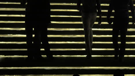 Silhouetten-Von-Menschen,-Die-Vor-Der-Beleuchtung-Einer-Goldenen-Treppe-In-Bangkok,-Thailand,-Auf-Und-Ab-Gehen