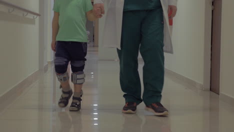 Doctor-and-child-walking-in-hospital-corridor
