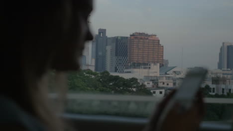 Woman-with-cell-going-by-bus-in-Bangkok-Thailand