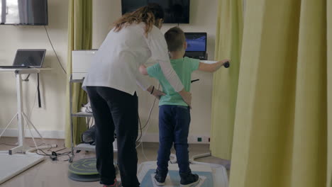 Centro-De-Rehabilitación-Evexia-Doctora-Examina-A-Un-Niño-Pequeño-Con-Un-Equipo-Especial-En-La-Sala-De-La-Clínica