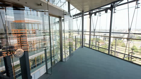 High-resolution-Video-from-a-high-floor-inside-Düsseldorf's-Stadttor,-featuring-extensive-glass-architecture-with-reflections-of-another-building,-captured-in-good-weather