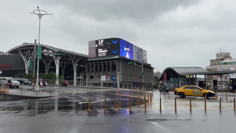 Vista-De-La-Calle-Lluviosa-Con-El-Telón-De-Fondo-De-La-Estación-De-Tren-De-Keelung-En-La-Ciudad-De-Keelung,-Distrito-De-Ren&#39;ai,-Taiwán