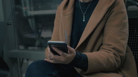 Close-up-view-of-woman-hands-when-she-writing-message-on-her-smartphone-in-the-subway-wagon