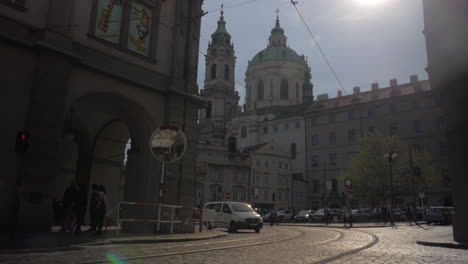 Vista-De-La-Plaza-De-La-Ciudad-Vieja-De-La-Iglesia-De-San-Nicolás-En-Praga-En-El-Día-Del-Sol-Y-La-Carretera-Con-Automóviles-En-Primer-Plano-República-Checa