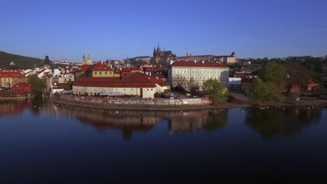 Aerial-shot-of-waterside-red-rooftop-buildings-in-Prague