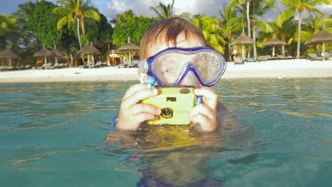 Kind-Badet-Im-Meer-Und-Fotografiert-Mit-Wasserdichter-Kamera