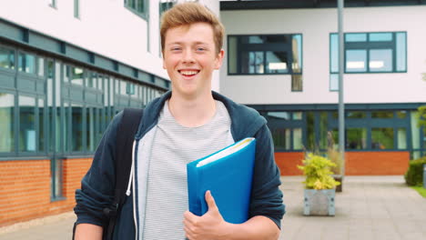 Portrait-Of-Male-Student-Standing-Outside-College-Building