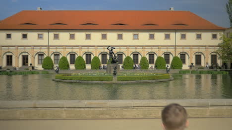 Zeitlupenansicht-Eines-Kleinen-Jungen,-Der-Zum-Brunnen-Rennt-Und-Münzen-Ins-Wasser-Wirft,-Prag,-Tschechische-Republik