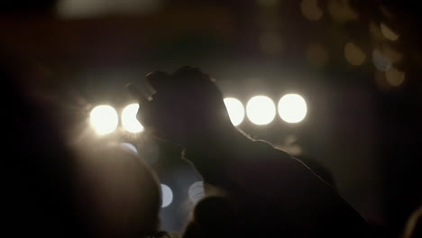 Slow-motion-shot-from-behind-of-swinging-hands-and-heads-at-the-concert