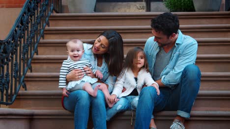 Young-family-with-two-kids-sitting-on-front-stoop,-Brooklyn