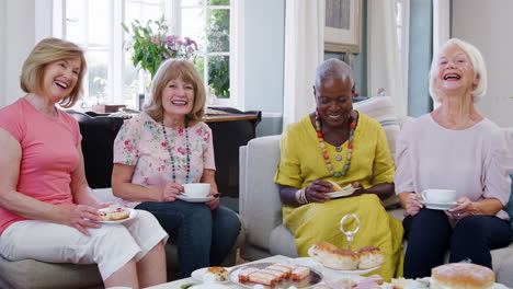 Senior-Female-Friends-Enjoying-Afternoon-Tea-At-Home-Together