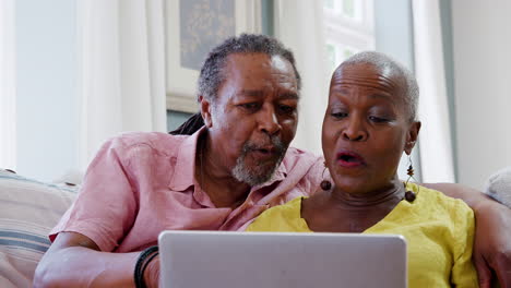 Senior-Couple-Using-Laptop-To-Connect-With-Family-For-Video-Call