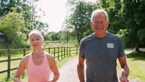 Healthy-Senior-Couple-Enjoying-Run-Through-Countryside-Together