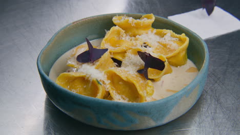 Cook-Decorates-Plate-with-Ravioli-in-Cream-Sauce