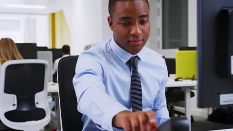 Young-black-man-using-a-telephone-in-an-office