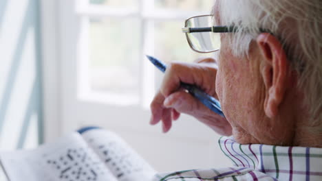 Senior-man-doing--crossword,-close-up