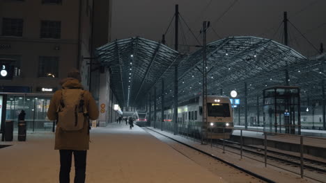 Tren-Saliendo-De-La-Estación-Por-La-Noche-Y-Hombre-Haciendo-Vídeo-En-El-Móvil