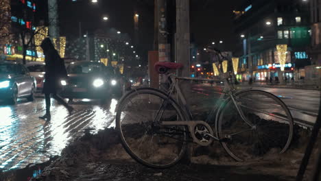 Vista-Nocturna-De-La-Calle-Con-Autos-Caminando,-Gente-Y-Bicicleta-Izquierda.