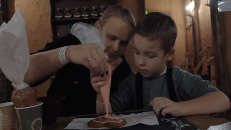 Kind-Und-Mutter-Verzieren-Plätzchen-Mit-Zuckerguss