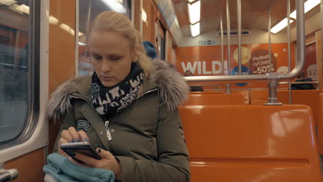 Mujer-Pasando-El-Tiempo-Con-El-Móvil-Durante-Un-Viaje-Rutinario-En-Metro.