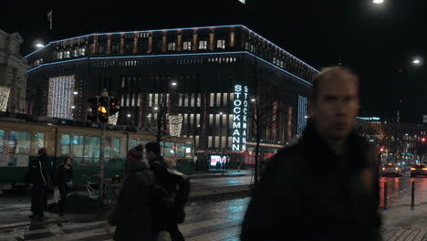 Straße-Mit-Stockmann-Einkaufszentrum,-Straßenbahn-Und-Personenverkehr-Im-Nächtlichen-Helsinki