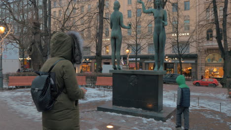 Woman-with-son-taking-pictures-in-Esplanadi-Park-Helsinki-Finland