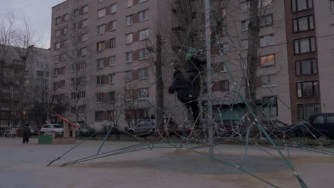 Children-having-fun-with-rope-web-climber-on-playground