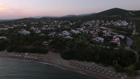 Toma-Aérea-De-La-Playa-Y-Villas-De-La-Playa-De-Trikorfo,-Grecia.