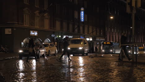 Calle-Pavimentada-Con-Tráfico-De-Coches-Y-Personas-En-La-Noche-Helsinki-Finlandia