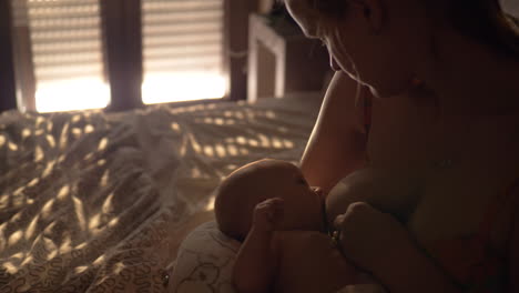 Mother-breastfeeding-baby-in-bedroom