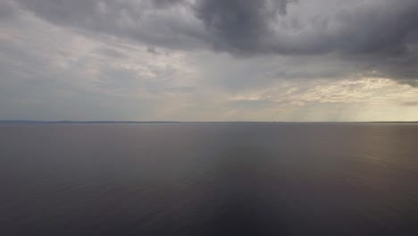 Aerial-view-of-quiet-sea-grey-clouds-in-evening-sky