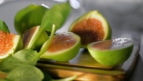 Basil-leaves-falling-on-cut-green-figs