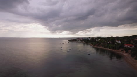 Coastal-resort-sea-and-grey-clouds-in-the-sky-aerial-Trikorfo-Beach-Greece