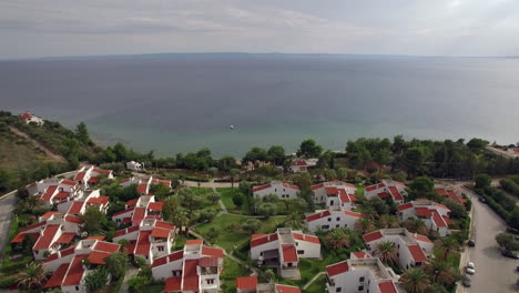 Resort-area-with-cottages-on-the-coast-of-vast-blue-sea-aerial