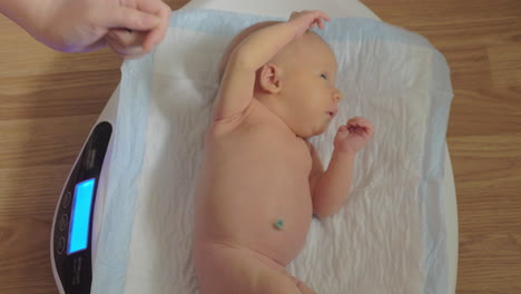 Wiegen-Eines-Neugeborenen-Auf-Einer-Elektronischen-Waage