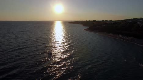 Aerial-view-of-shoreline-and-sea-with-boats-at-sunset